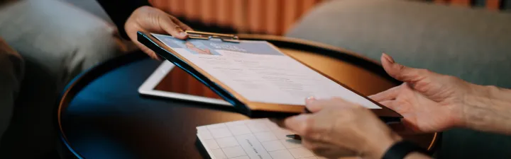 person-in-black-long-sleeve-shirt-writing-on-white-paper